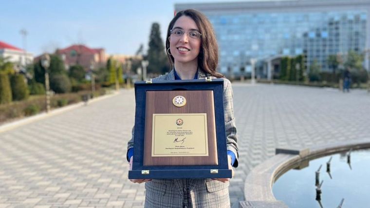Gulnar Abdullayeva holding the Azerbaijan Presidential Award for Youth 2024 framed award
