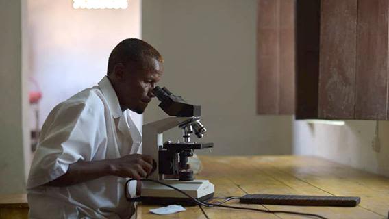 A lab technician checks a blood sample for malaria