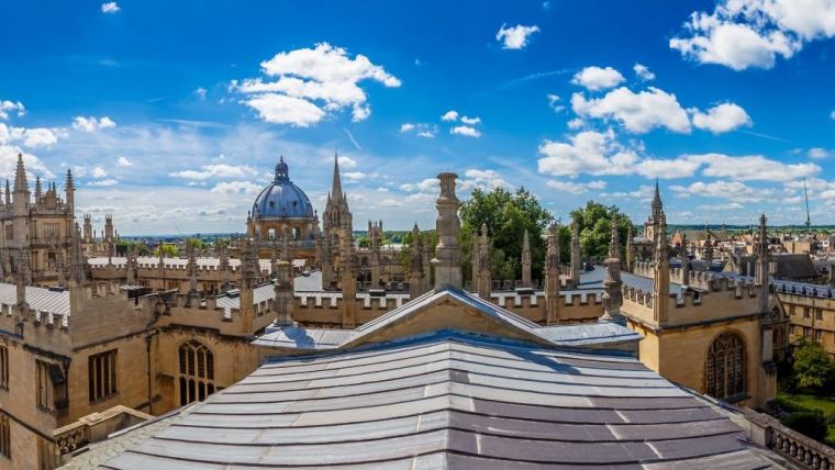 Panorama view of the Oxford skyline, with the Sheldonian Theatre, Bodleiain Library and St Mary's Church all visible against a blue sky.