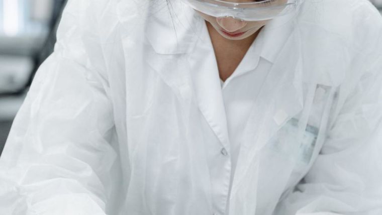 Asian woman at a lab with white hospital gown