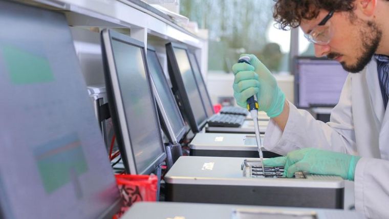 Scientist pipetting onto a GridION in a Nanopore lab